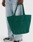 A dark green nylon tote bag with two hand straps and a front pocket.