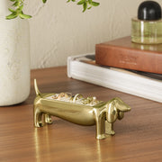 A gold dachshund shaped ring holder.