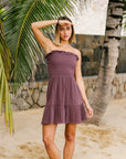 A dark purple ish grey smocked dress with a strapless neckline.