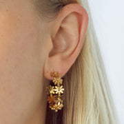 Gold hoops made of gold shaped daisies.