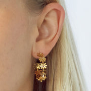Gold hoops made of gold shaped daisies.