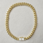 A chunky gold necklace with a mother of pearl inlay.