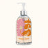 On an ivory background is a clear bottle of hand soap with a pink and orange floral illustration on the front with a pump and text along the bottom that reads, "Hand Soap". 