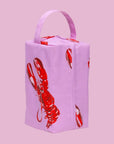 A pink and red dopp kit cosmetic bag with red lobster prints.