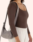 A grey / tan nylon handbag with an adjustable strap to make it a crossbody or a shoulder bag.