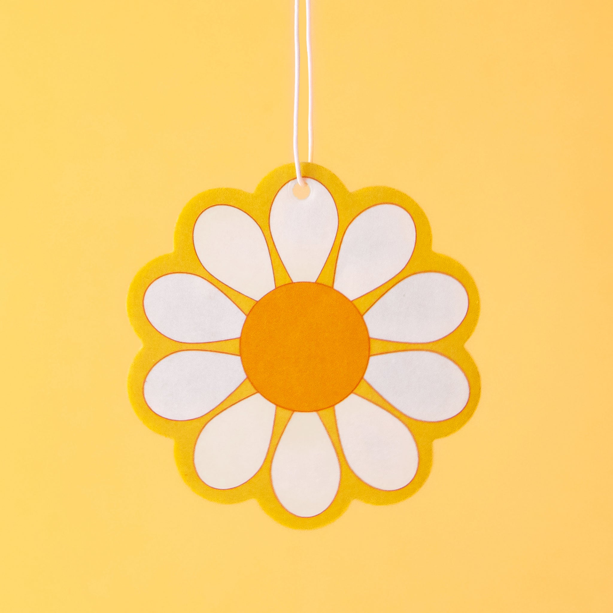 A yellow, white and orange daisy shaped air freshener.
