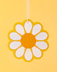 A yellow, white and orange daisy shaped air freshener.