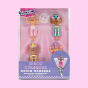 On a light pink background is four drink markers in the shape of cowboys with different colored chaps and hats on.