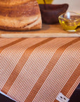 A burnt orange and white striped kitchen towel.