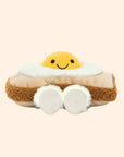 A tan and yellow toast and egg shaped stuffed toy with a smiling face.