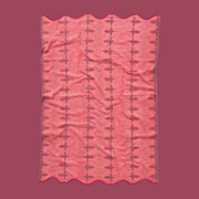 A pink and red piping edge bath towel with a wavy end on both sides.