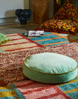 A round velvet jade green floor cushion.