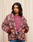 A maroon and white floral print quilted jacket.