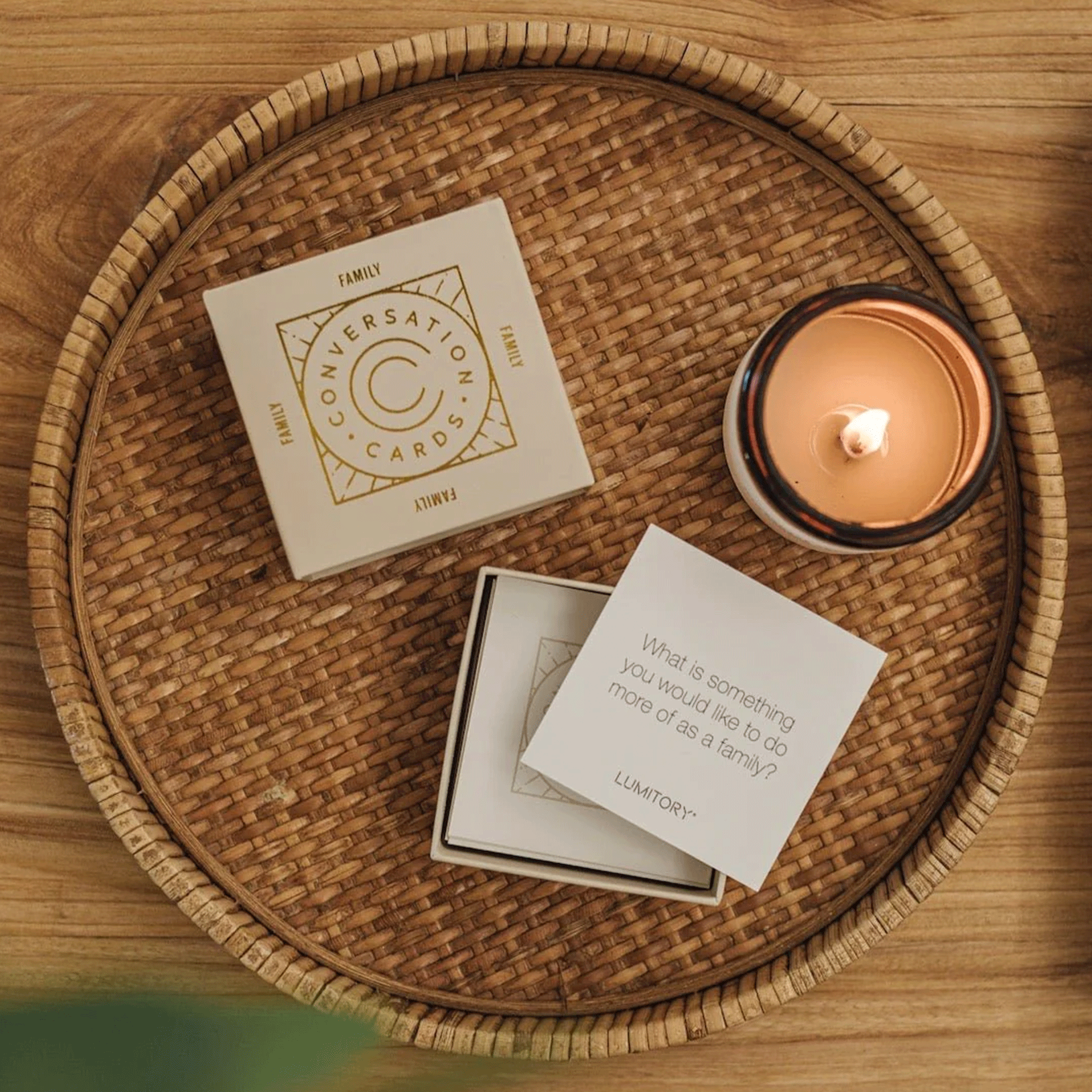 On a wicker tray is a box of conversation cards with a question that reads, "What is something you would like to do more of as a family?".
