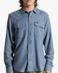 A blue flannel material button up shirt for men with long sleeves and two front pockets.