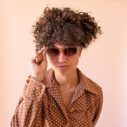 A translucent tan pair of cat-eye shaped sunglasses.