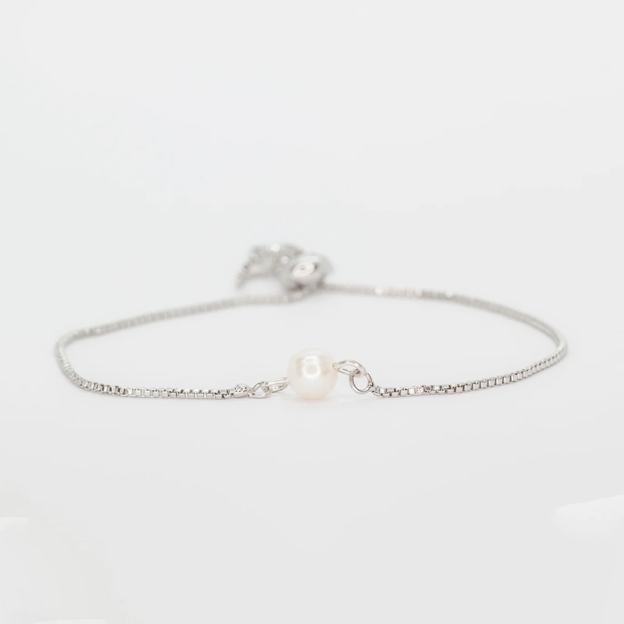 A circle freshwater pearl in the center of a dainty chain bracelet.