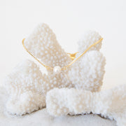 A circle freshwater pearl in the center of a dainty chain bracelet.