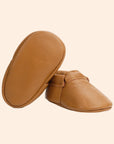 A pair of tan leather moccasins.