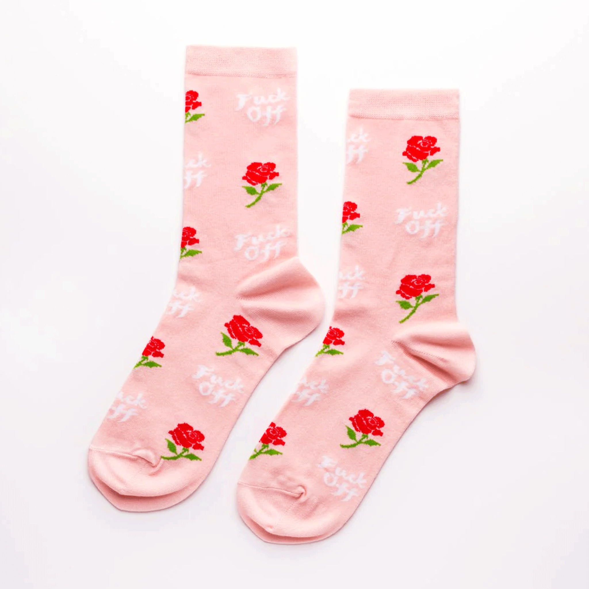 On a white background is a light pink pair of socks with a rose print and white text print that reads, "Fuck Off". 