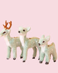 On a peachy background is three different sized mint green furry reindeer ornaments.