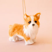 On a tan background is an orange and white furry corgi ornament.