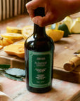 A bottle of olive oil with a green label that reads, 'Flamingo Estate Heirloom Garlic Extra Virgin Olive Oil'.