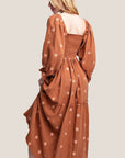 A rust / brown long-sleeve dress with flower embroidery.