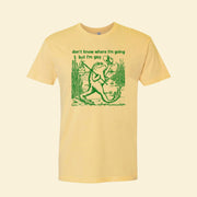 A yellow t-shirt with green screen-printing that reads, "don't know where I'm going but I'm gay". and a frog design with a hat and a walking stick over the shoulder.