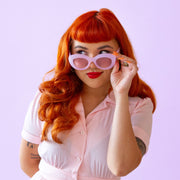 On a purple background is a model wearing the Gemma sunglasses in the shade amethyst.