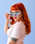On a blue background is a model wearing the Gemma Sunglasses in the shade Lapis.