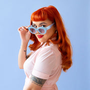 On a blue background is a model wearing the Gemma Sunglasses in the shade Lapis.