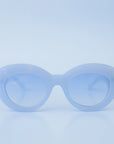 On a blue background is a model wearing the Gemma Sunglasses in the shade Lapis.