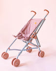 A pink and dark pink gingham printed stroller for dolls with pink wheels.