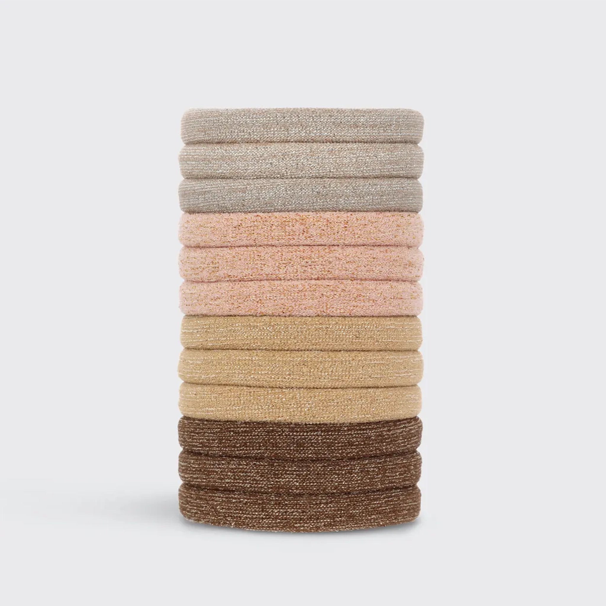 A stack of neutral elastic hair ties with a glitter finish. The colors range from a neutral tans, brown, and grey. 
