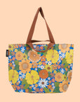 A multi colored floral tote with brown canvas handles.