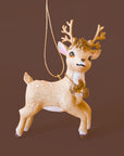 A reindeer shaped ornament in a beige color.