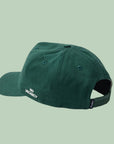 A dark green baseball hat with a snapback adjustable strap and white embroidered text on the side that reads, 'No Vacancy'.
