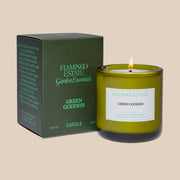 A green glass candle with a white label that reads, 'Flamingo Estate Green Goddess'.