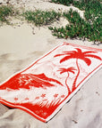 A beach towel with a palm tree design.