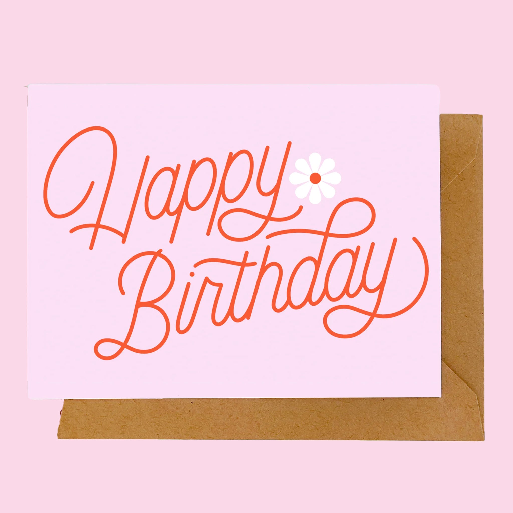 On a pink background is a pink card with red cursive text that reads, &quot;Happy Birthday&quot; with a graphic of a daisy on the side. 
