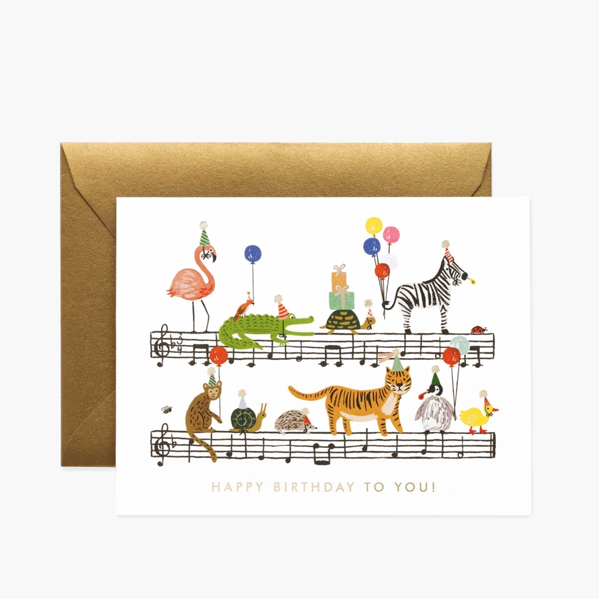 On a white background is a white card with an illustration of animals with party hats and balloons standing along bars of music and gold text at the bottom that reads, "Happy Birthday To You!".