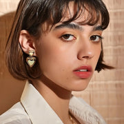 A pair of gold double heart earrings.