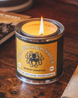 On a wood background is a tin candle with a yellow label featuring a octopus graphic and text arched above it that reads, "Hell or High Water Bradley Mountain".