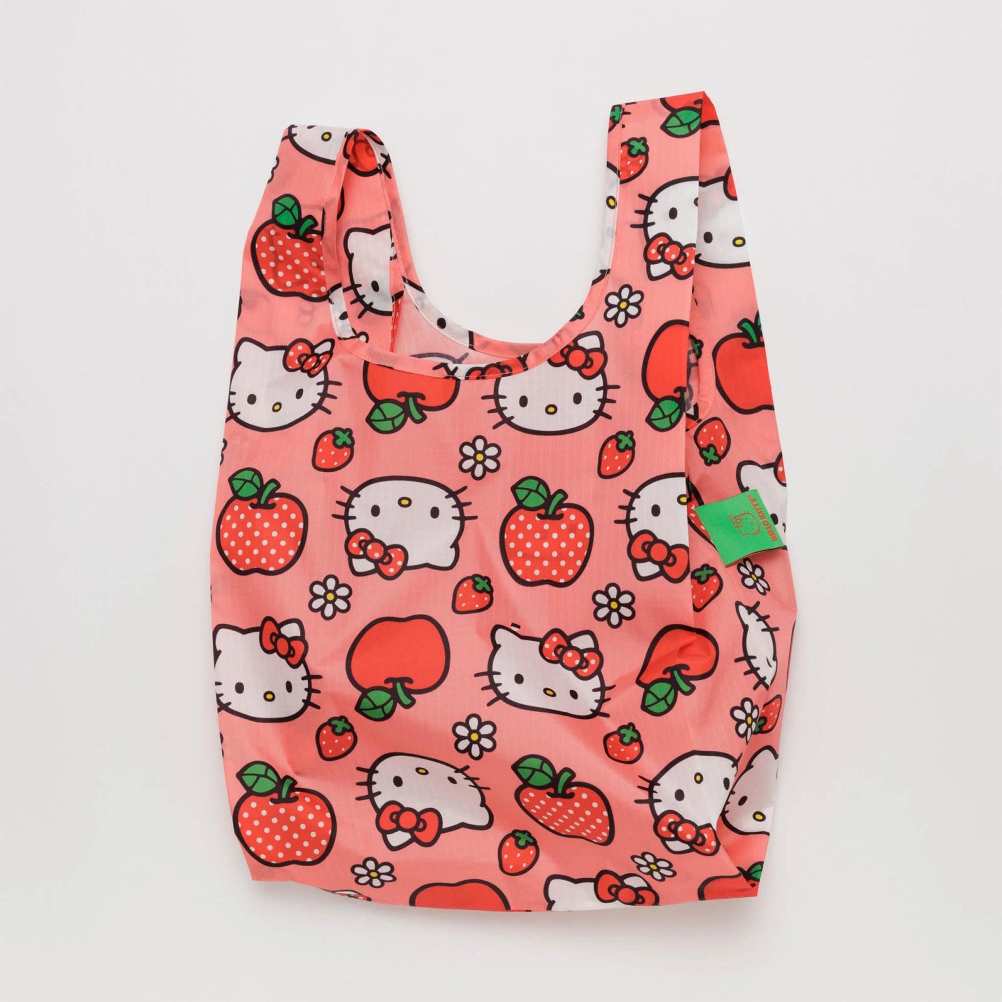 On a white background is a hello kitty and apple printed nylon tote bag. 