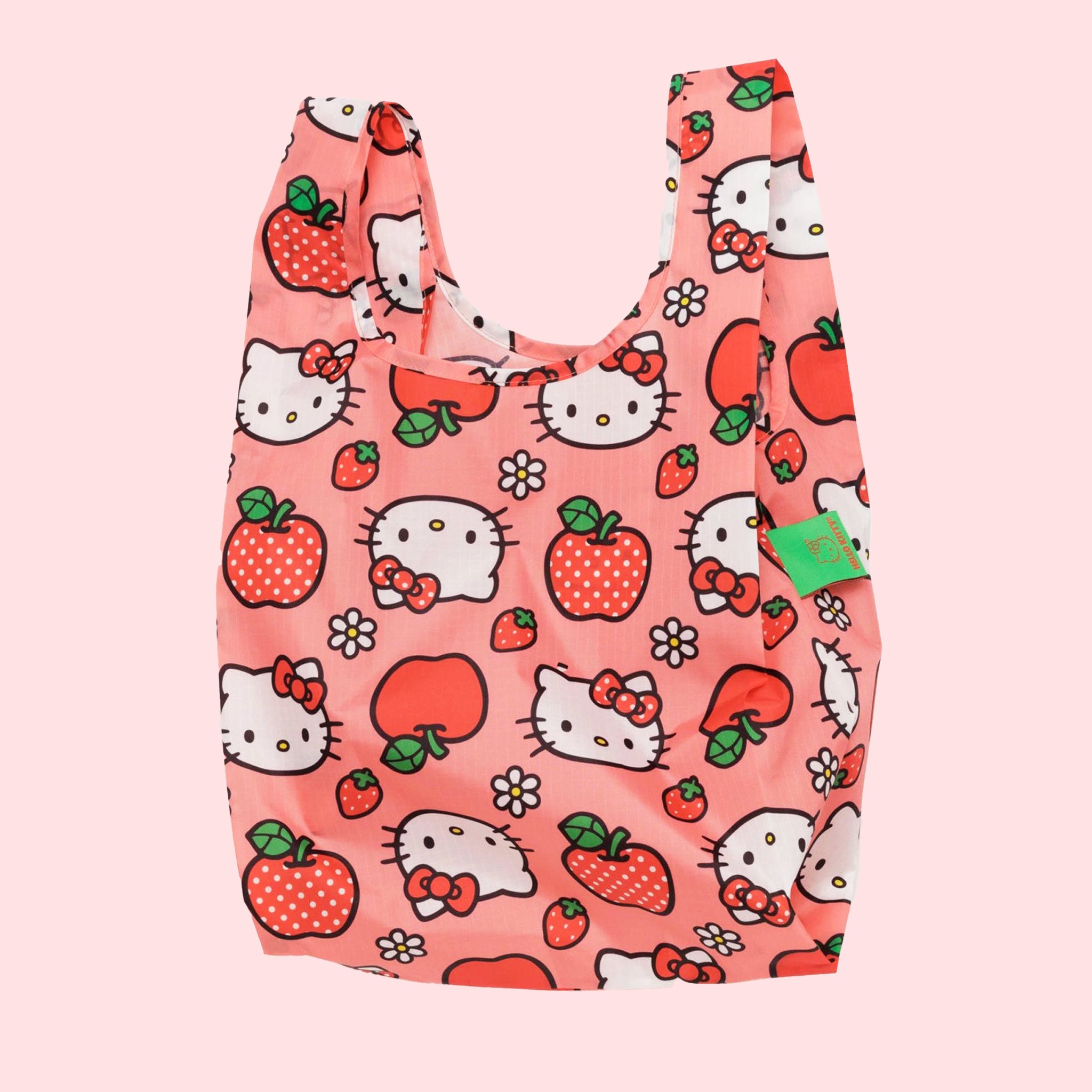 On a white background is a pink nylon bag with hello kitty and apple designs all over.