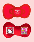 A red bow shaped box filled with two containers of candy.