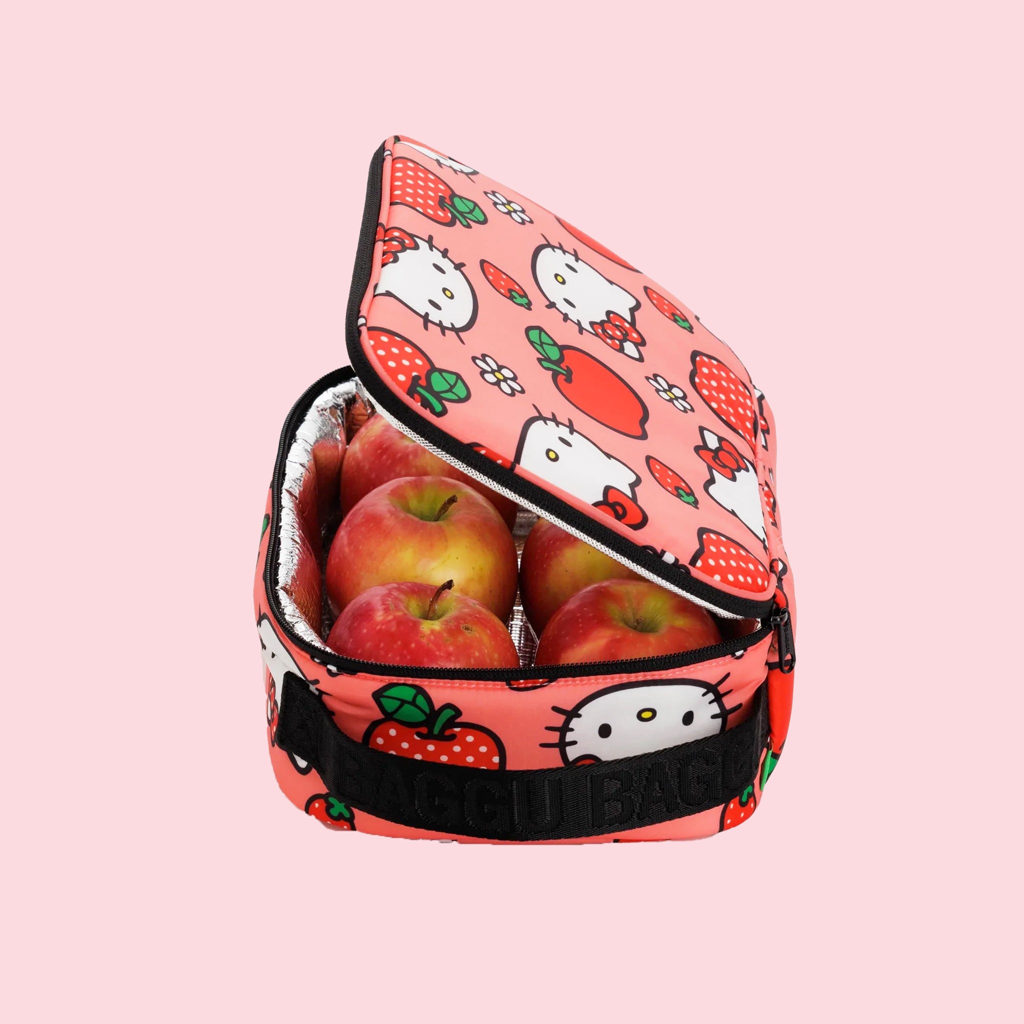 A pink and red lunch box with a Hello Kitty Apple pattern and black strap.