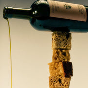 On a white background is a brown glass bottle of olive oil with a label on the front that reads, "California Harvest from 150 Year Old Trees".