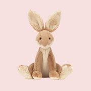 A tan rabbit shaped stuffed animal toy with big ears.